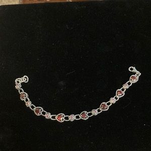 Gorgeous Sterling silver bracelet surrounded by lab created rubies and garnets